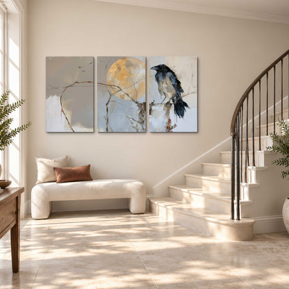 A dark raven beside a golden moon amid pale blue and cream painterly strokes 3 piece canvas wall art styled in an interior