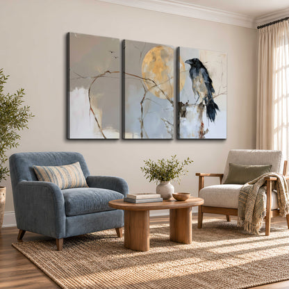 A dark raven beside a golden moon amid pale blue and cream painterly strokes 3 piece canvas wall art styled in an interior