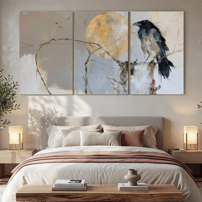 A dark raven beside a golden moon amid pale blue and cream painterly strokes 3 piece canvas wall art displayed in a bedroom