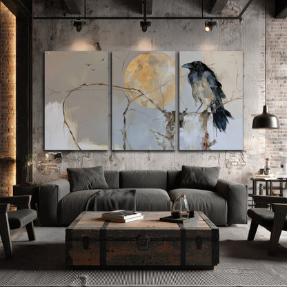 A dark raven beside a golden moon amid pale blue and cream painterly strokes 3 piece canvas wall art displayed in a industrial room
