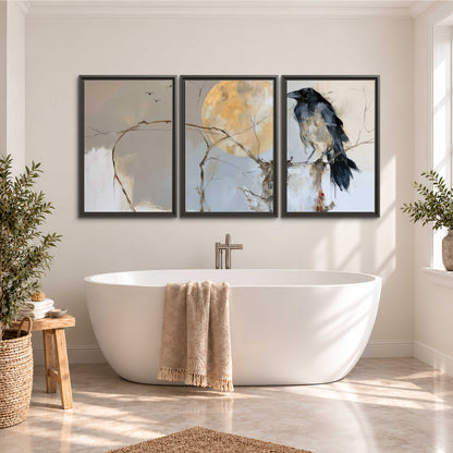 A dark raven beside a golden moon amid pale blue and cream painterly strokes 3 piece framed canvas wall art styled in an interior