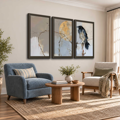 A dark raven beside a golden moon amid pale blue and cream painterly strokes 3 piece framed canvas wall art styled in an interior