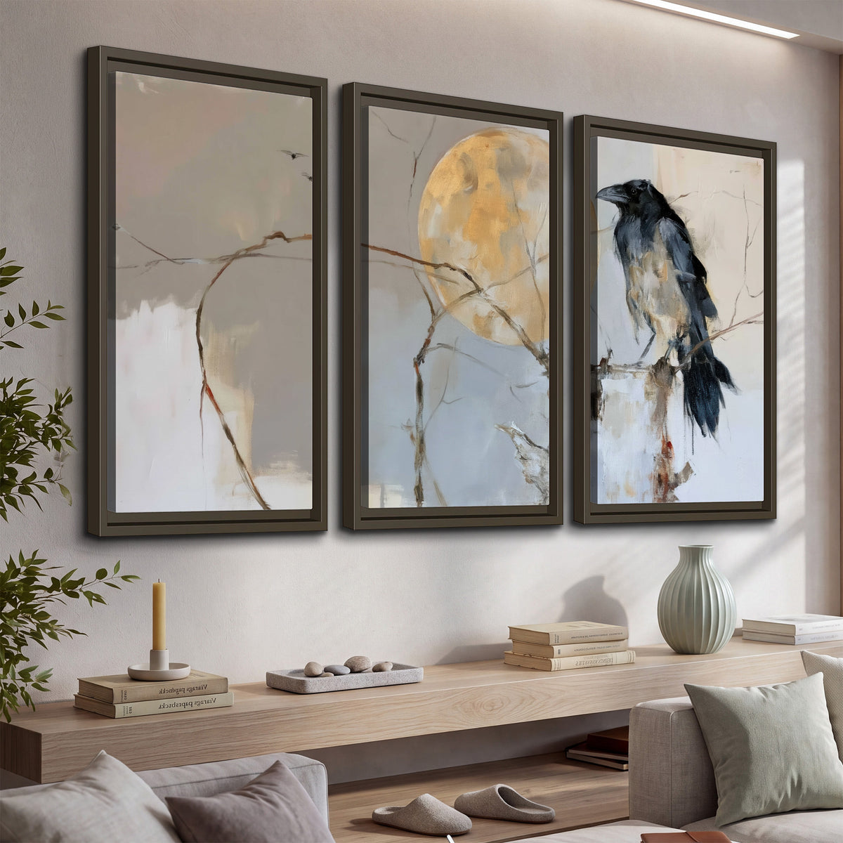 A dark raven beside a golden moon amid pale blue and cream painterly strokes 3 piece framed canvas wall art displayed in a console