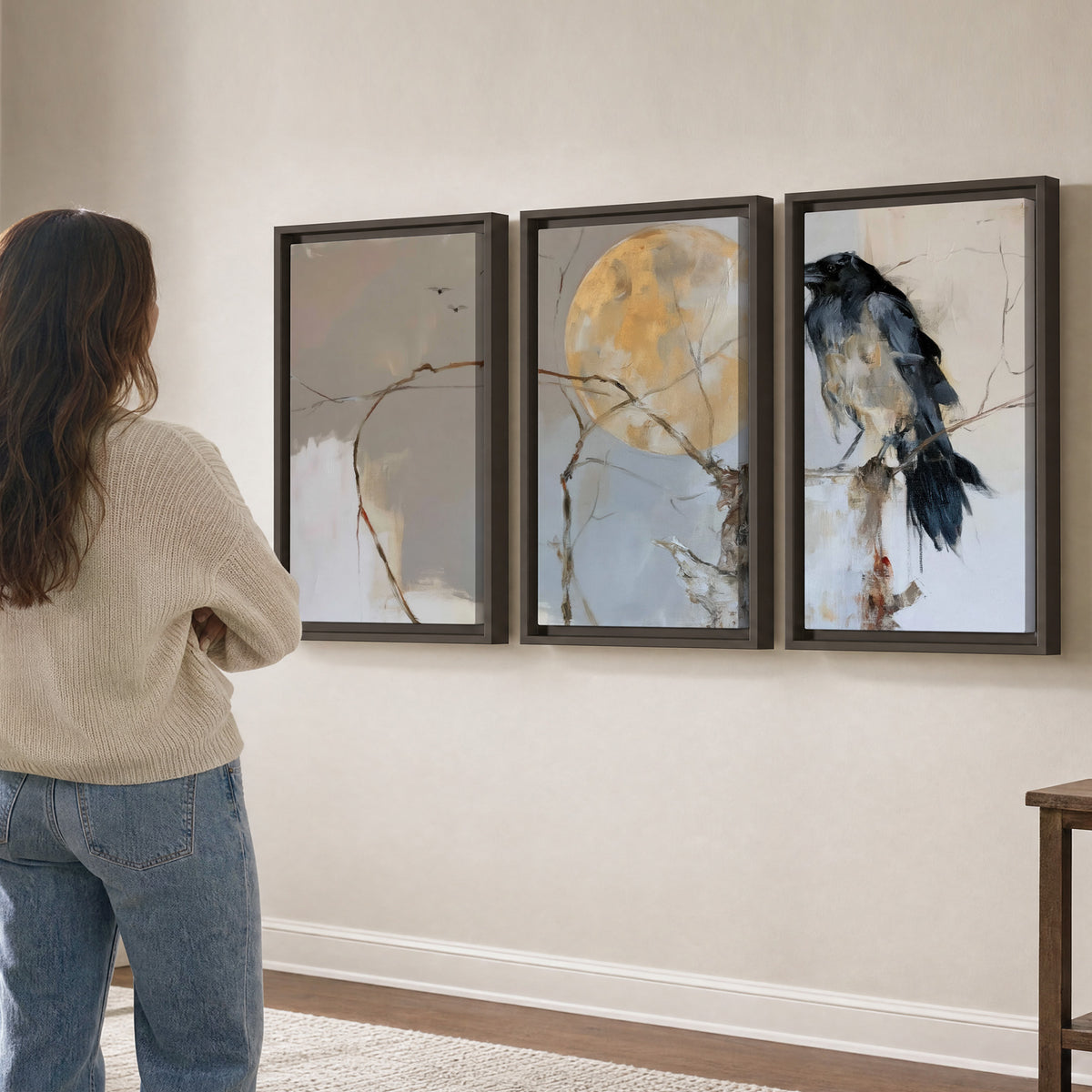 A dark raven beside a golden moon amid pale blue and cream painterly strokes 3 piece framed canvas wall art three panel arrangement on a wall