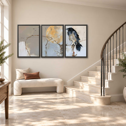 A dark raven beside a golden moon amid pale blue and cream painterly strokes 3 piece framed canvas wall art styled in an interior
