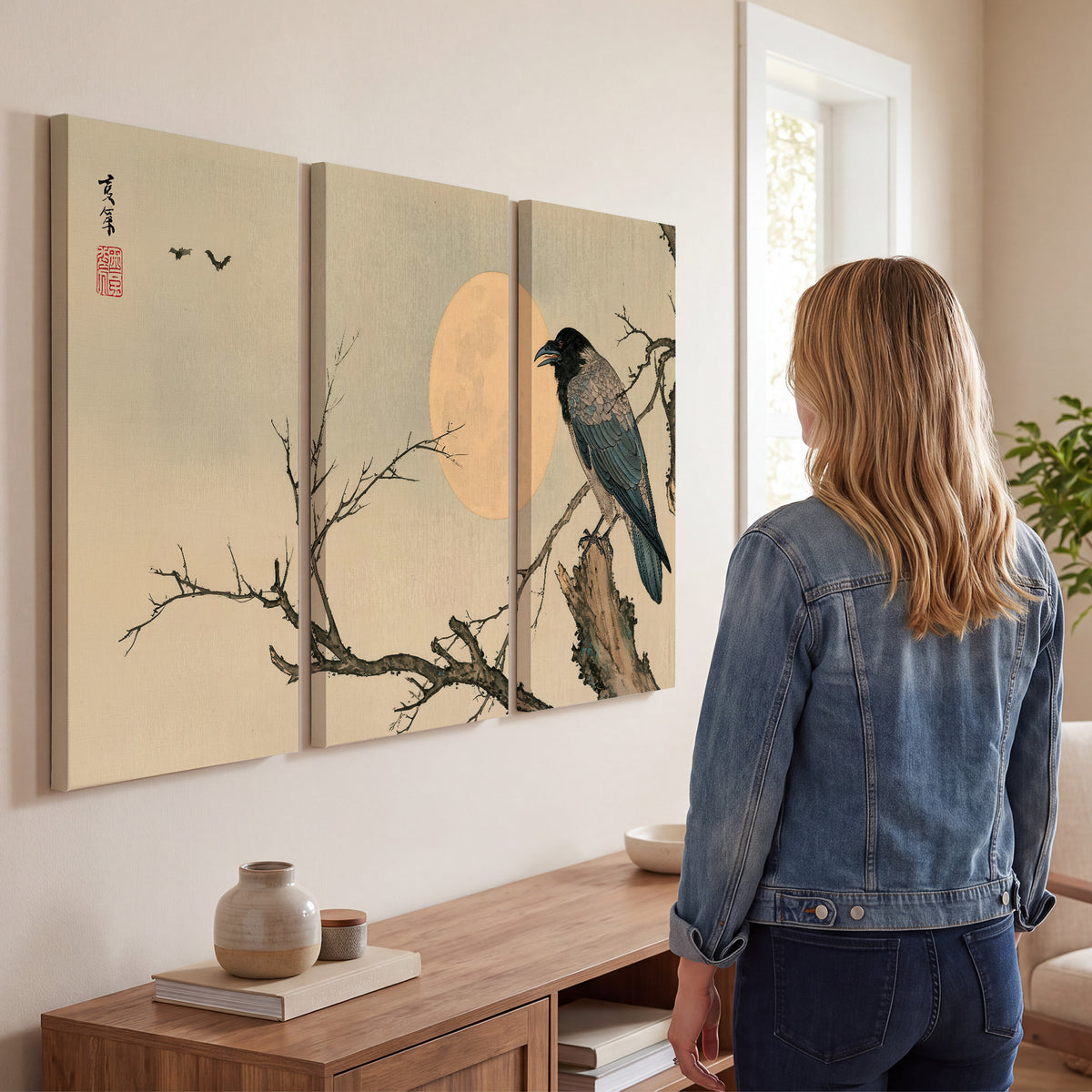 A dark raven perched on a bare branch beside a warm full moon 3 piece canvas wall art three panel arrangement on a wall