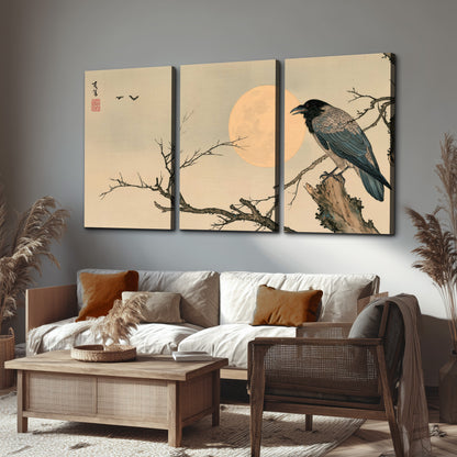 A dark raven perched on a bare branch beside a warm full moon 3 piece canvas wall art displayed in a rustic living room