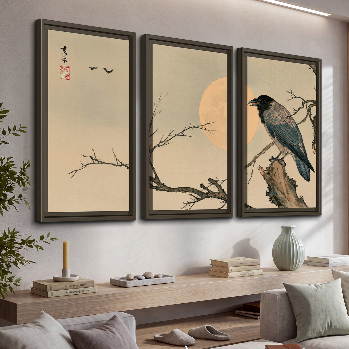 A dark raven perched on a bare branch beside a warm full moon 3 piece framed canvas wall art displayed in a console