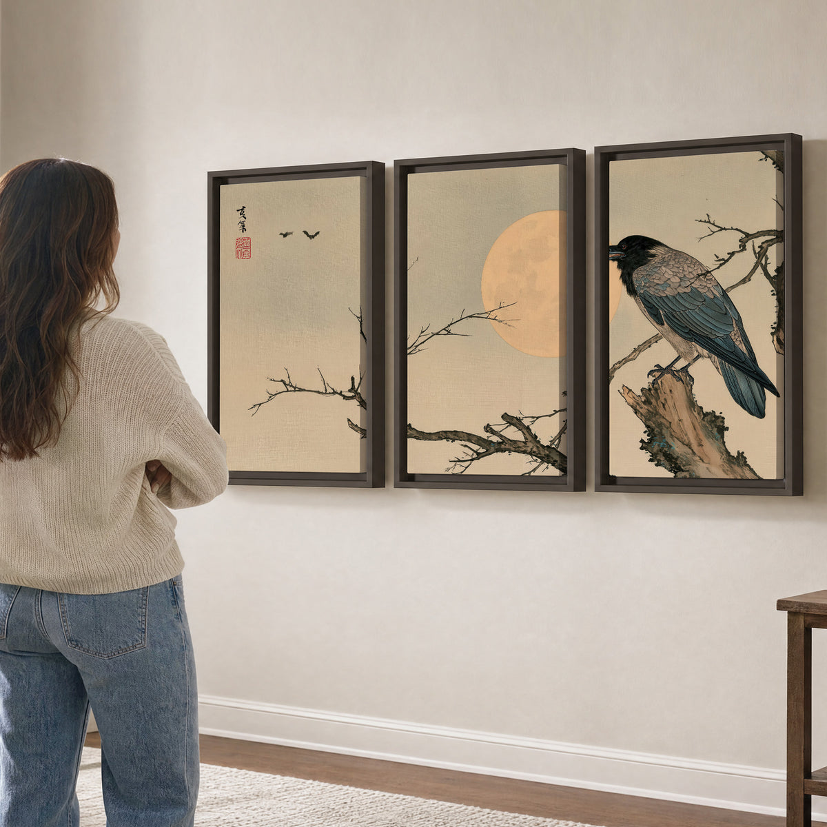 A dark raven perched on a bare branch beside a warm full moon 3 piece framed canvas wall art three panel arrangement on a wall