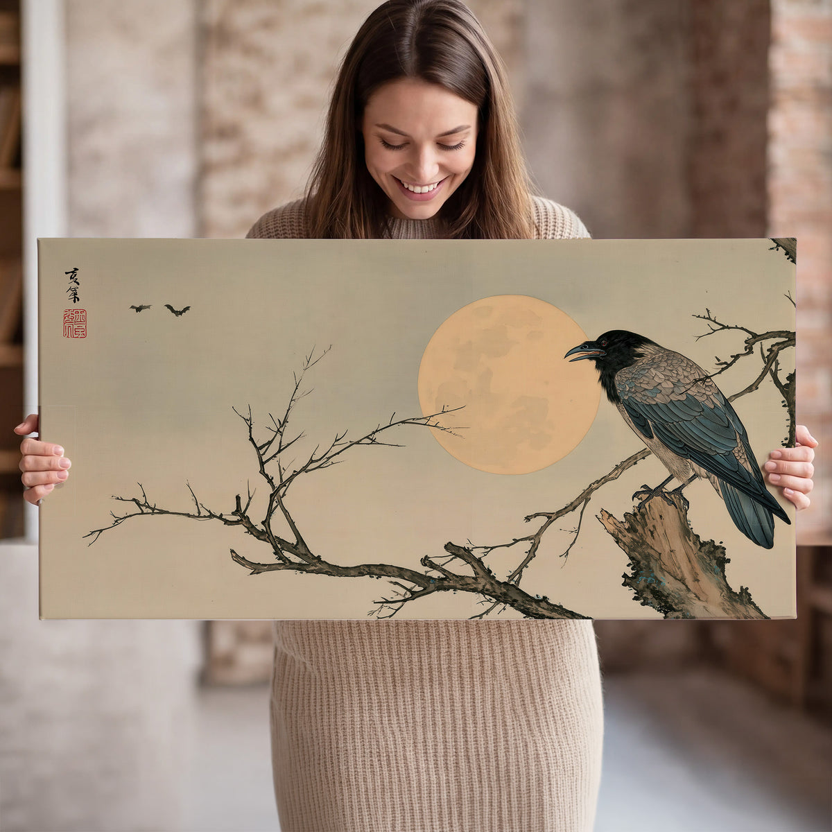 A dark raven perched on a bare branch beside a warm full moon single canvas wall art held in hands