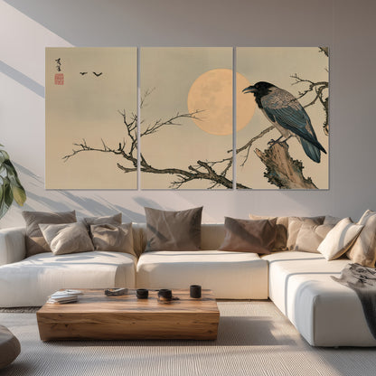 A dark raven perched on a bare branch beside a warm full moon set of 3 poster prints displayed in a living room