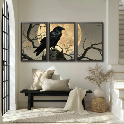 A black raven standing among bare branches in front of a large golden moon 3 piece framed canvas wall art displayed in a entryway