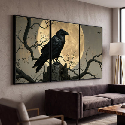 A black raven standing among bare branches in front of a large golden moon 3 piece framed canvas wall art displayed in a modern living room
