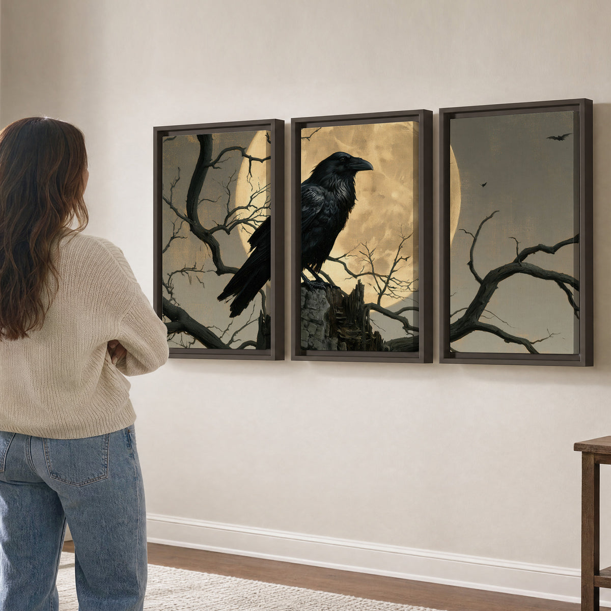 A black raven standing among bare branches in front of a large golden moon 3 piece framed canvas wall art three panel arrangement on a wall