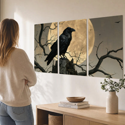 A black raven standing among bare branches in front of a large golden moon set of 3 poster prints three panel arrangement on a wall