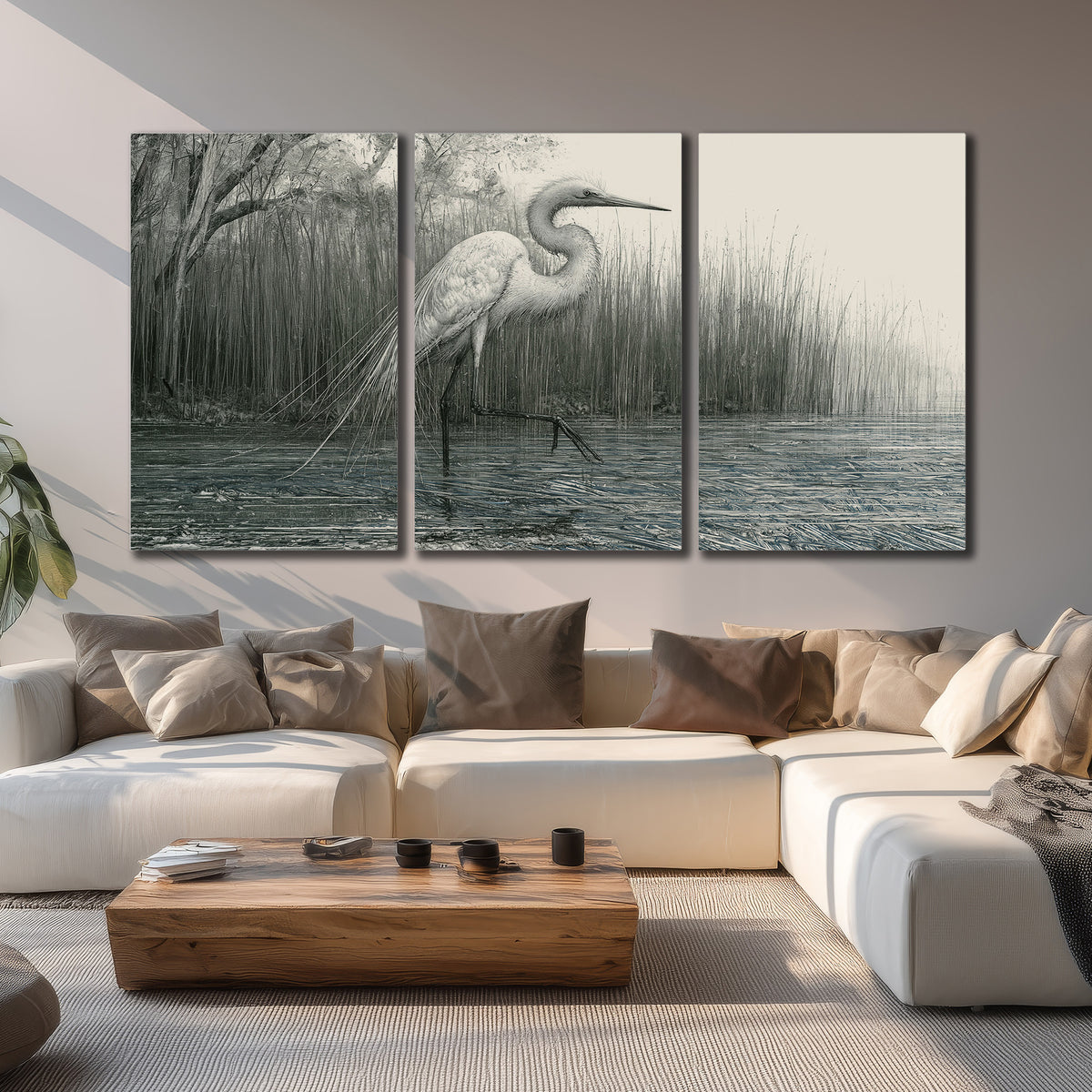 A pale long-legged heron standing beside tall reeds in a muted gray-green wetland 3 piece canvas wall art displayed in a living room