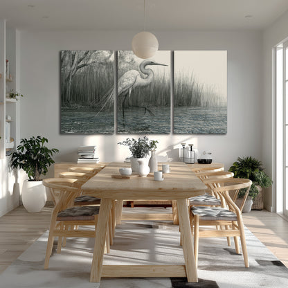 A pale long-legged heron standing beside tall reeds in a muted gray-green wetland 3 piece canvas wall art room and product view