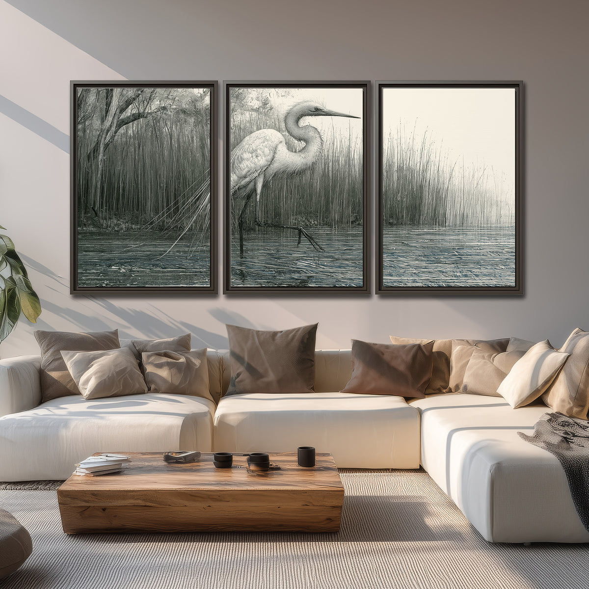 A pale long-legged heron standing beside tall reeds in a muted gray-green wetland 3 piece framed canvas wall art displayed in a living room