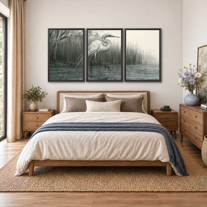 A pale long-legged heron standing beside tall reeds in a muted gray-green wetland 3 piece framed canvas wall art styled in an interior