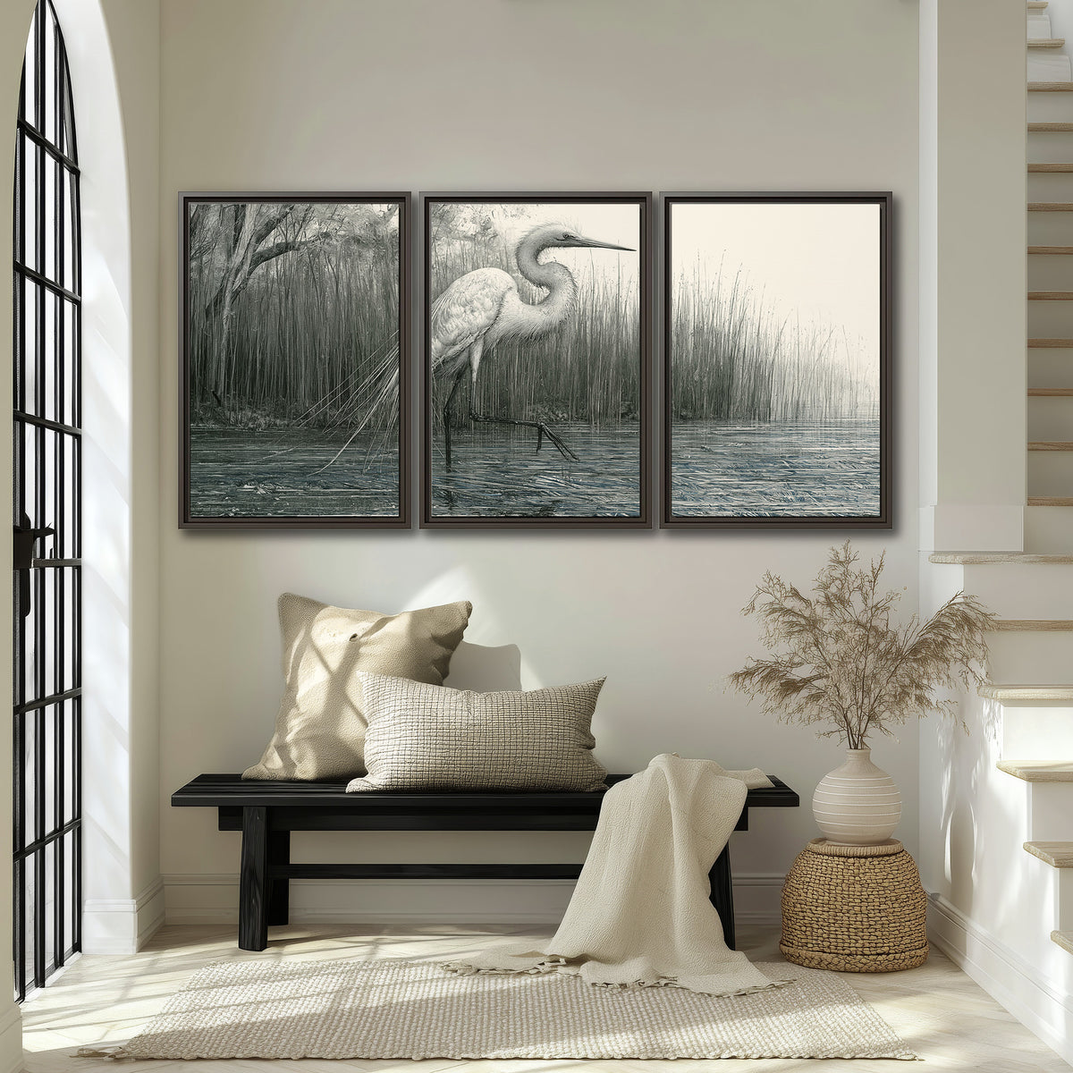A pale long-legged heron standing beside tall reeds in a muted gray-green wetland 3 piece framed canvas wall art displayed in a entryway