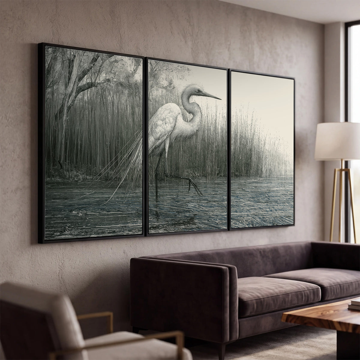 A pale long-legged heron standing beside tall reeds in a muted gray-green wetland 3 piece framed canvas wall art displayed in a modern living room