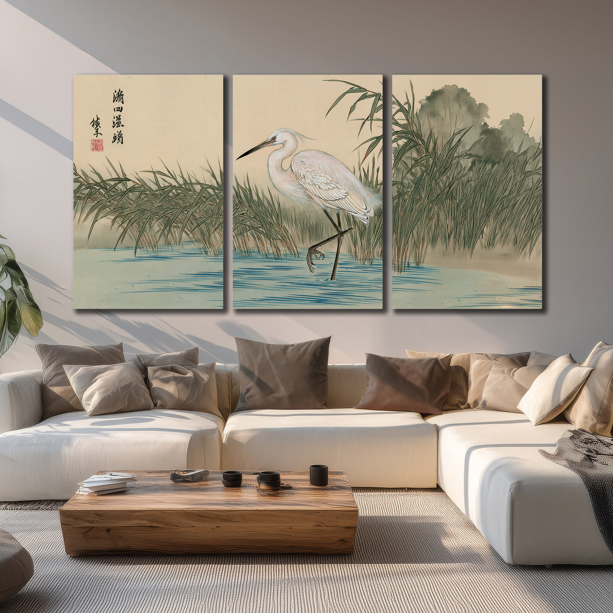 A white heron standing beside a quiet river with reeds and distant hills 3 piece canvas wall art displayed in a living room