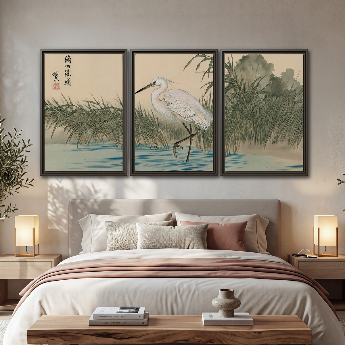 A white heron standing beside a quiet river with reeds and distant hills 3 piece framed canvas wall art displayed in a bedroom