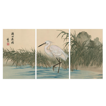 A white heron standing beside a quiet river with reeds and distant hills set of 3 poster prints viewed straight on