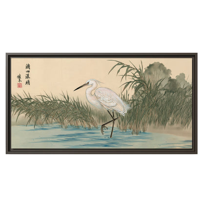 A white heron standing beside a quiet river with reeds and distant hills single framed canvas wall art viewed straight on