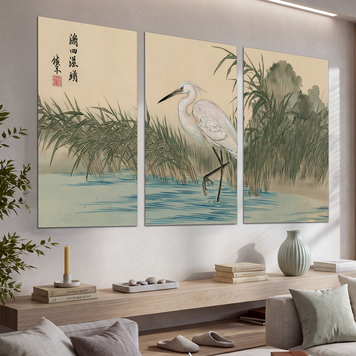 A white heron standing beside a quiet river with reeds and distant hills set of 3 poster prints displayed in a console