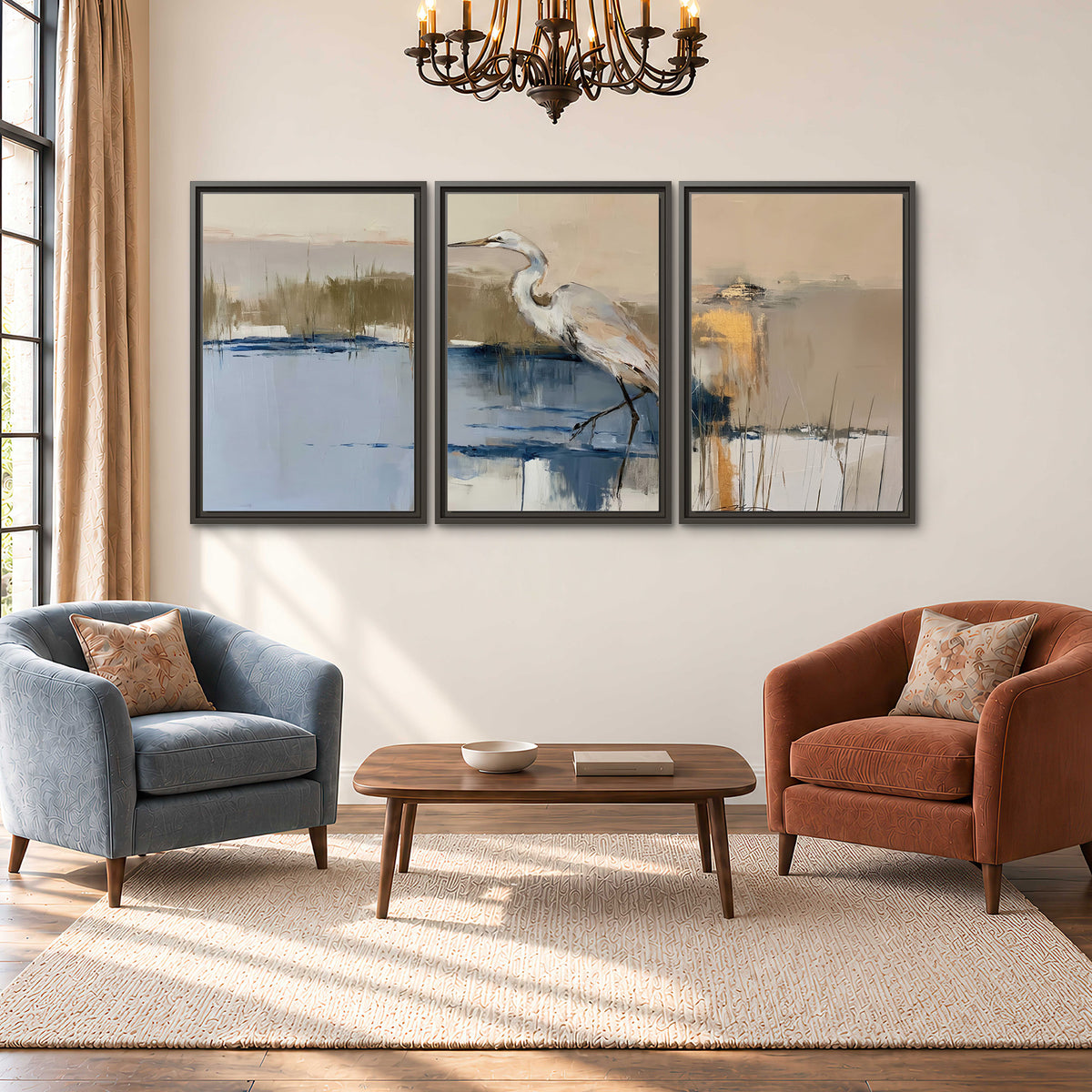 A slender heron standing in blue water among loose ochre and cream brushstrokes 3 piece framed canvas wall art styled in an interior