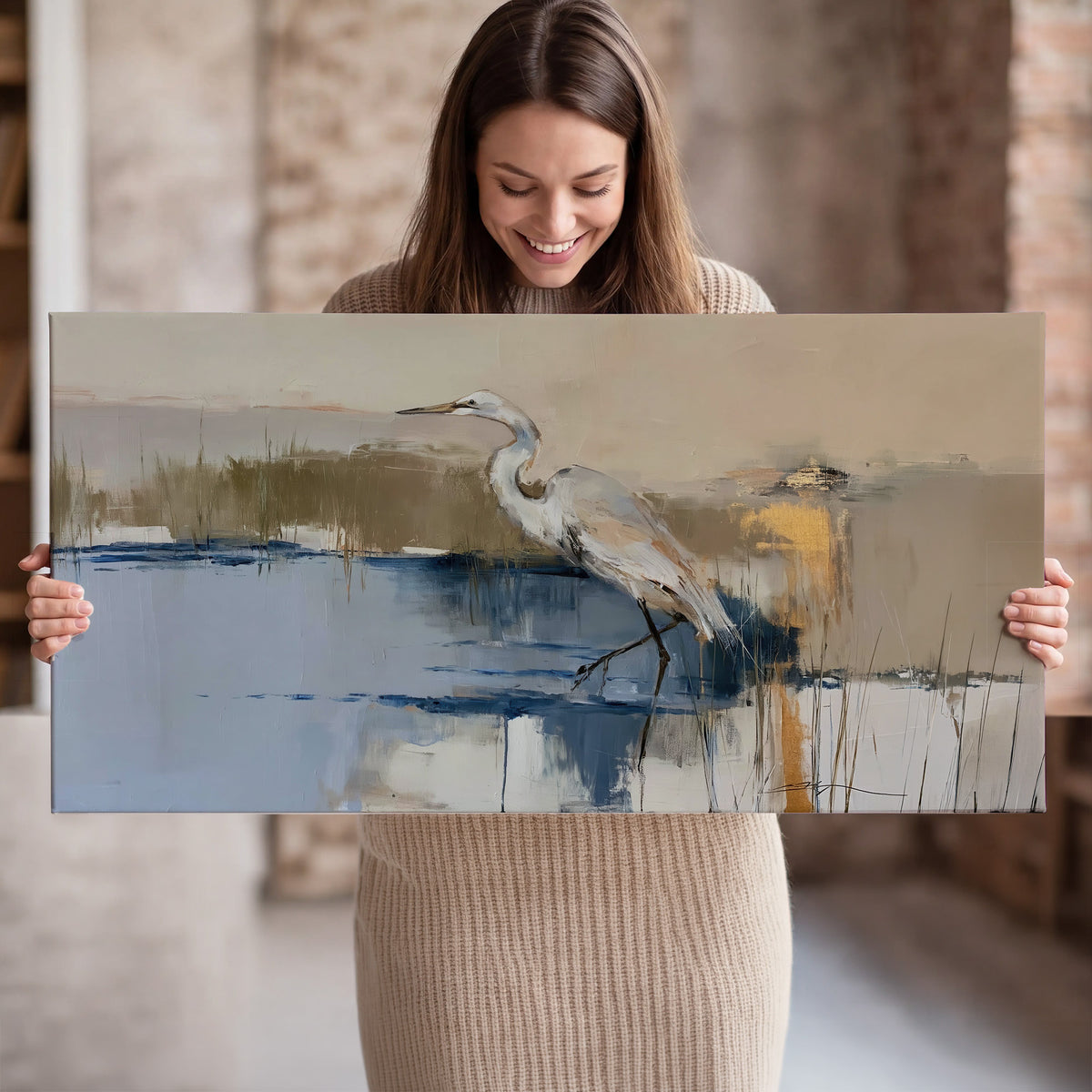 A slender heron standing in blue water among loose ochre and cream brushstrokes single canvas wall art held in hands