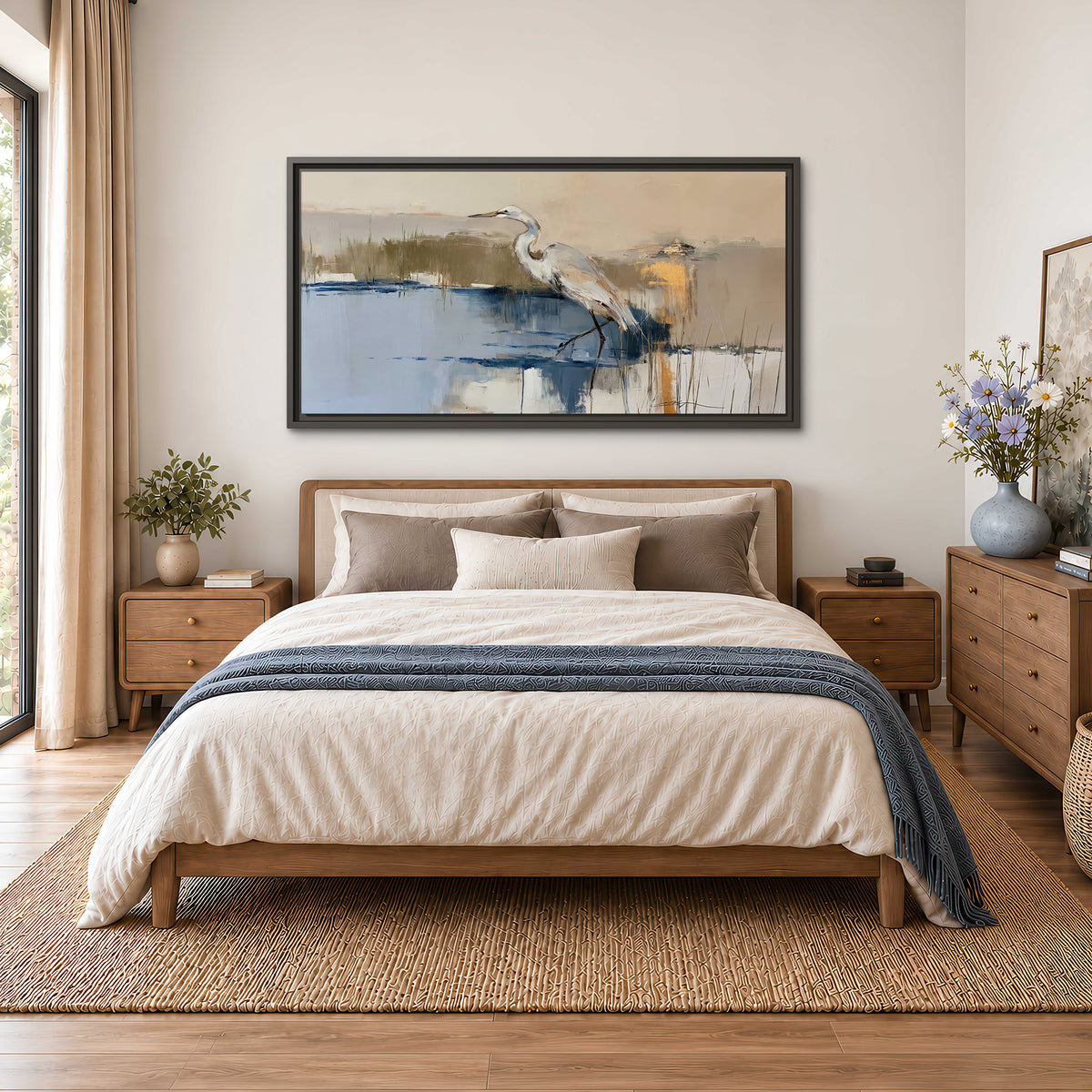 A slender heron standing in blue water among loose ochre and cream brushstrokes single framed canvas wall art styled in an interior