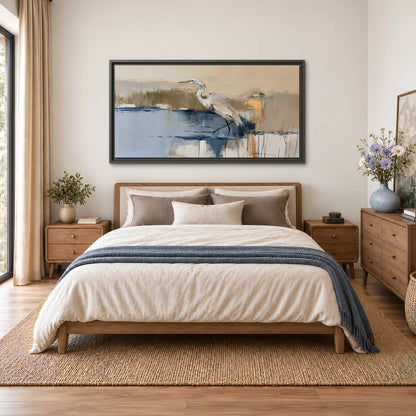 A slender heron standing in blue water among loose ochre and cream brushstrokes single framed canvas wall art styled in an interior