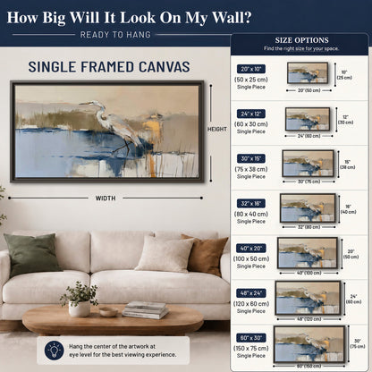 A slender heron standing in blue water among loose ochre and cream brushstrokes single framed canvas wall art size guide above a sofa; room view is illustrative