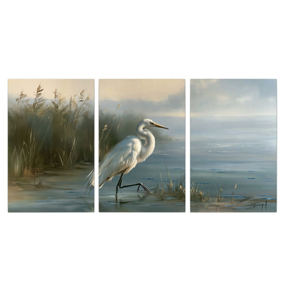 A white heron beside tall marsh grasses and still blue water 3 piece canvas wall art viewed straight on