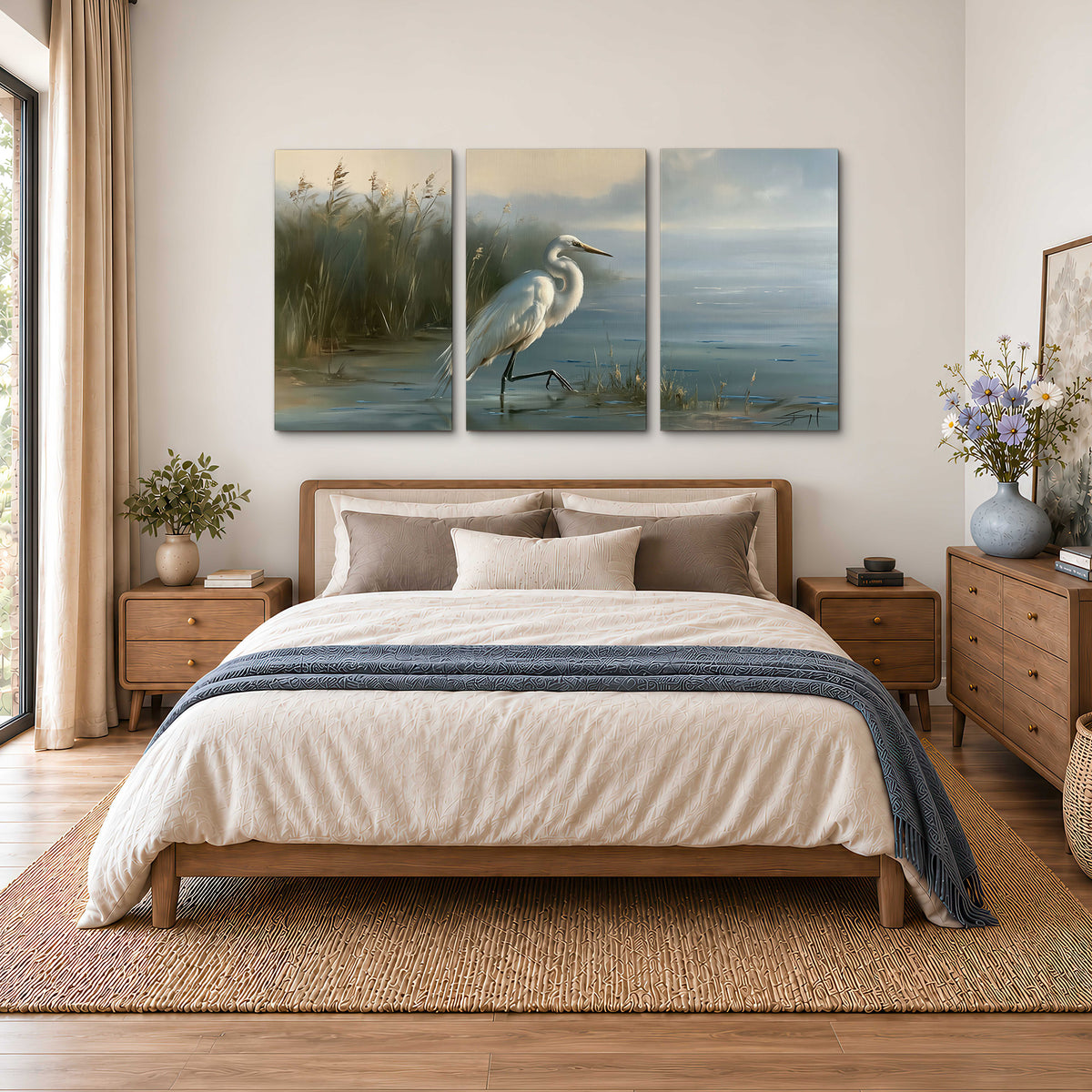A white heron beside tall marsh grasses and still blue water 3 piece canvas wall art styled in an interior