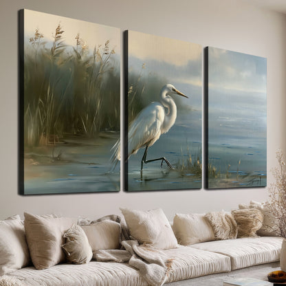A white heron beside tall marsh grasses and still blue water 3 piece canvas wall art room and product view