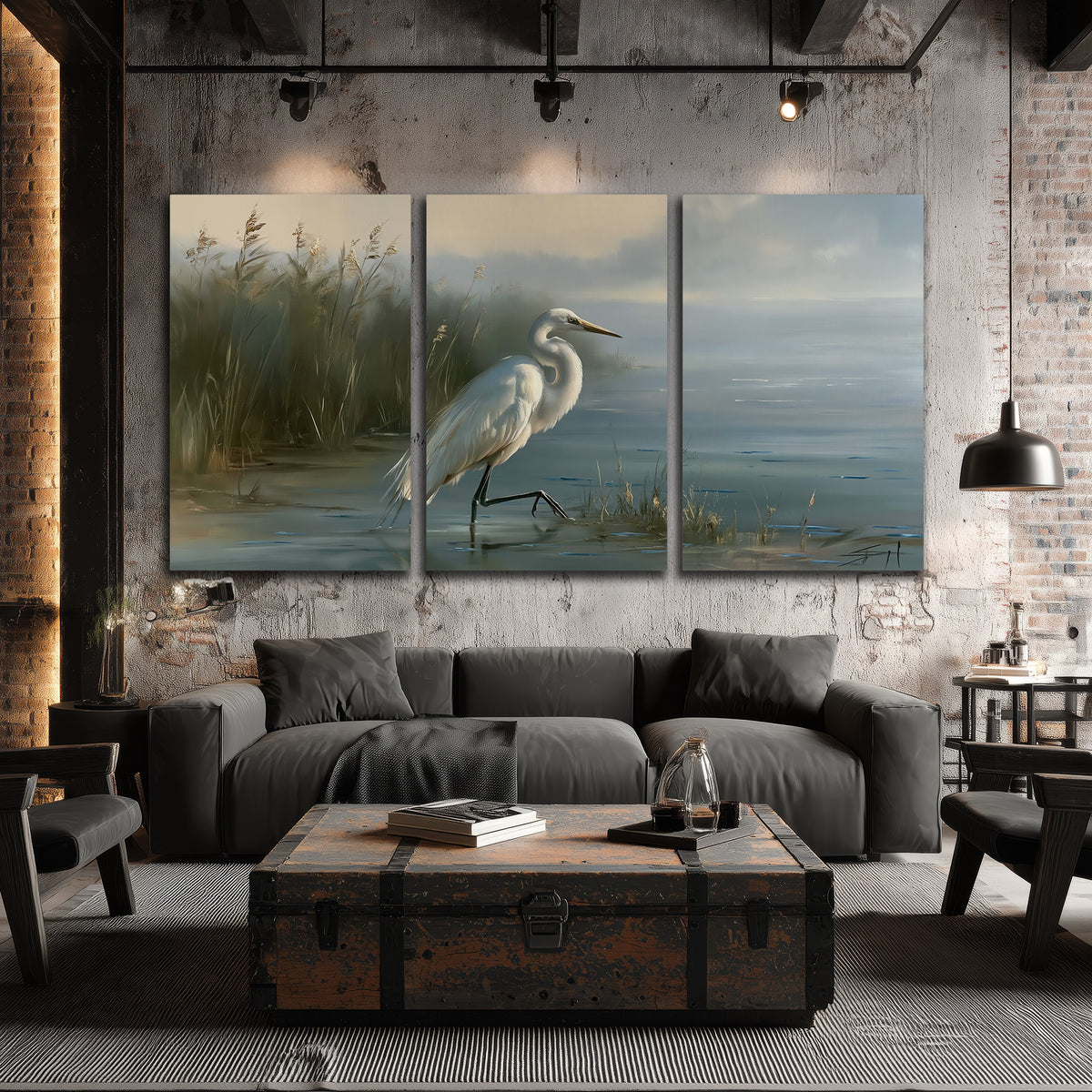 A white heron beside tall marsh grasses and still blue water 3 piece canvas wall art displayed in a industrial room