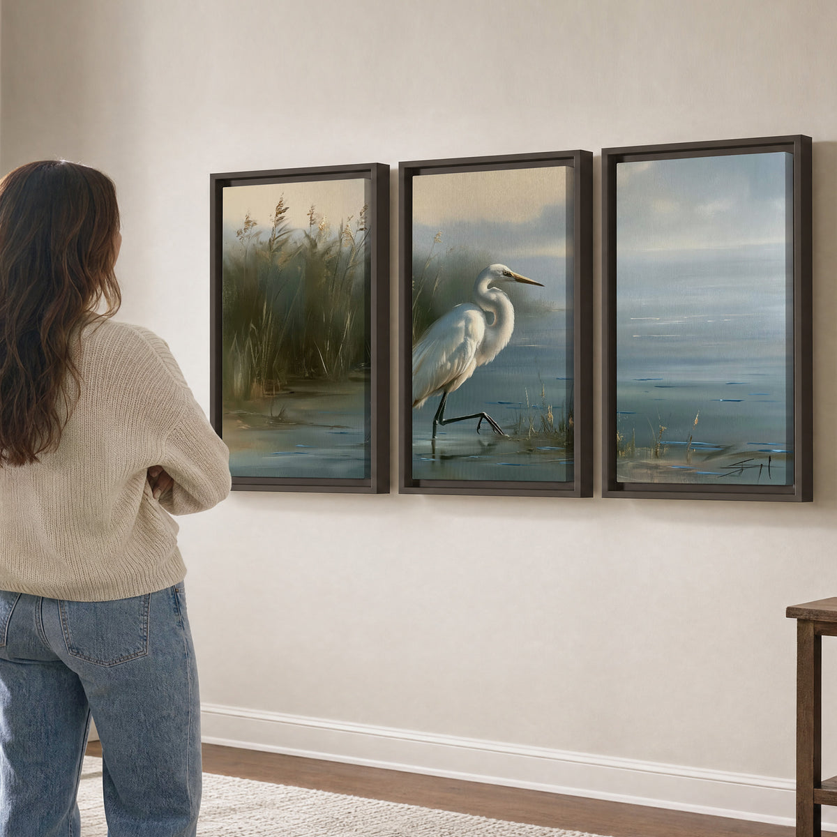 A white heron beside tall marsh grasses and still blue water 3 piece framed canvas wall art three panel arrangement on a wall