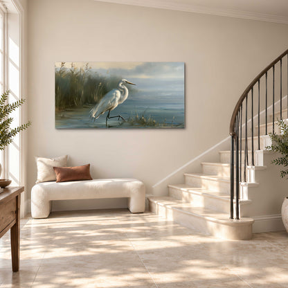 A white heron beside tall marsh grasses and still blue water single canvas wall art styled in an interior
