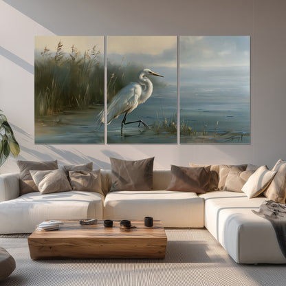 A white heron beside tall marsh grasses and still blue water set of 3 poster prints displayed in a living room
