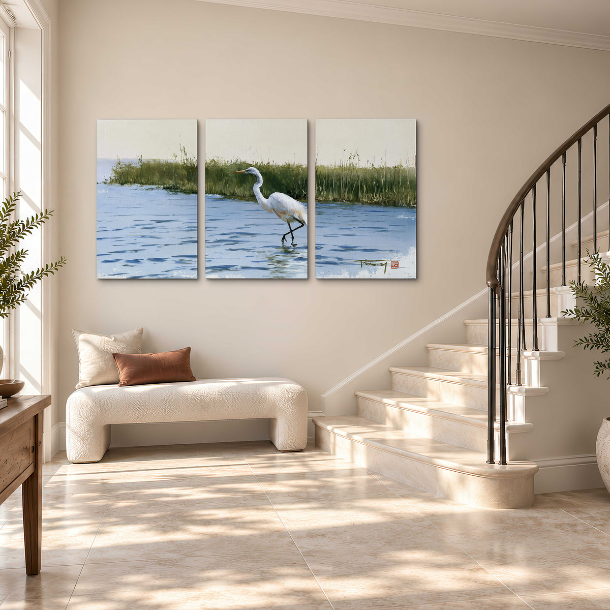 A white heron wading through bright blue water beside green reeds 3 piece canvas wall art styled in an interior