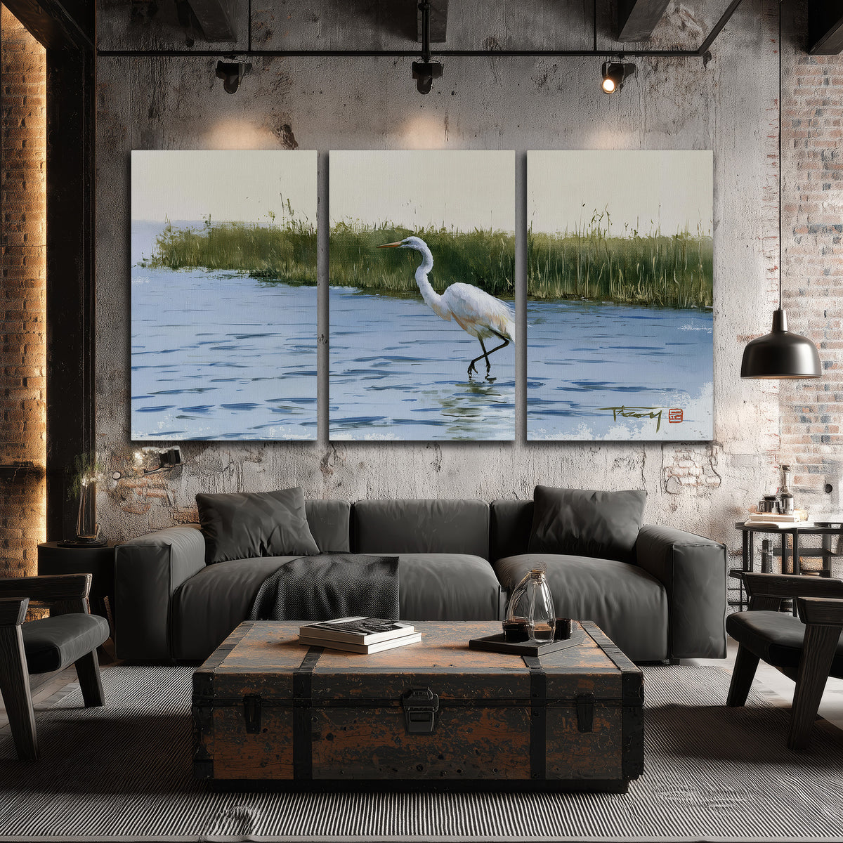 A white heron wading through bright blue water beside green reeds 3 piece canvas wall art displayed in a industrial room