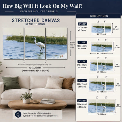 A white heron wading through bright blue water beside green reeds 3 piece canvas wall art size guide above a sofa; room view is illustrative