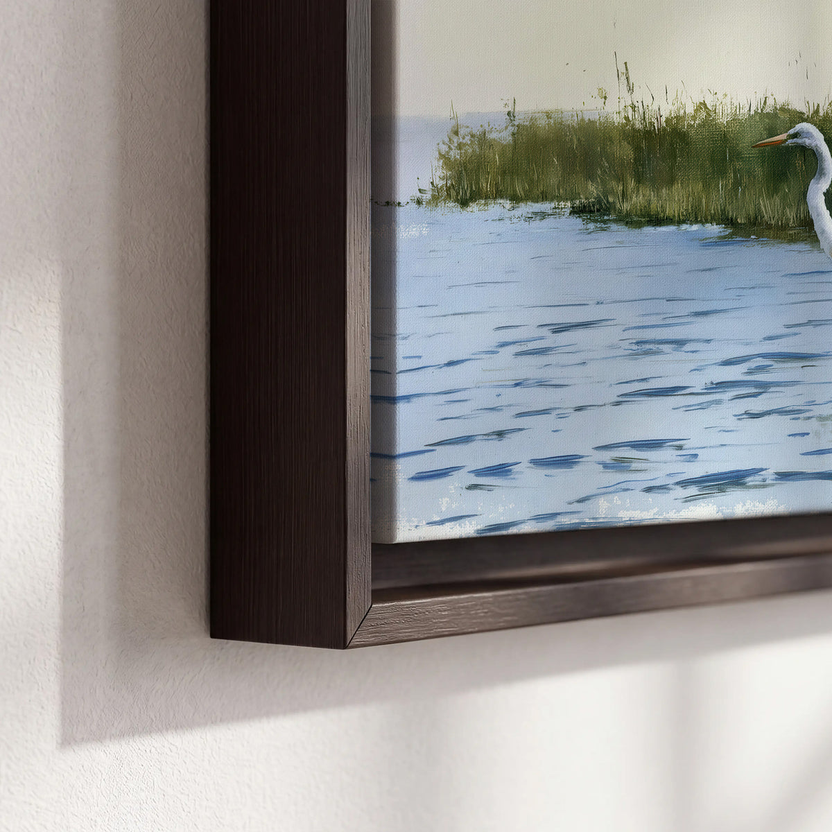 A white heron wading through bright blue water beside green reeds 3 piece framed canvas wall art material and edge close up