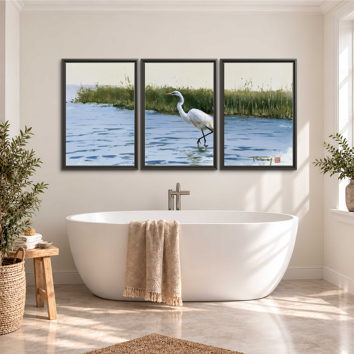 A white heron wading through bright blue water beside green reeds 3 piece framed canvas wall art styled in an interior