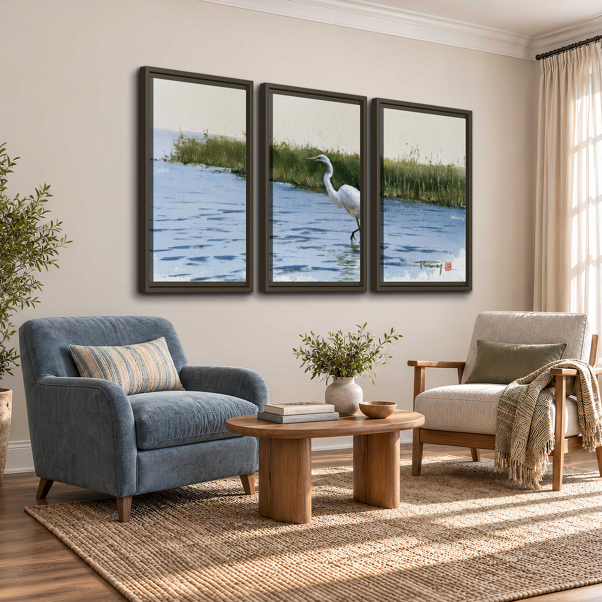 A white heron wading through bright blue water beside green reeds 3 piece framed canvas wall art styled in an interior