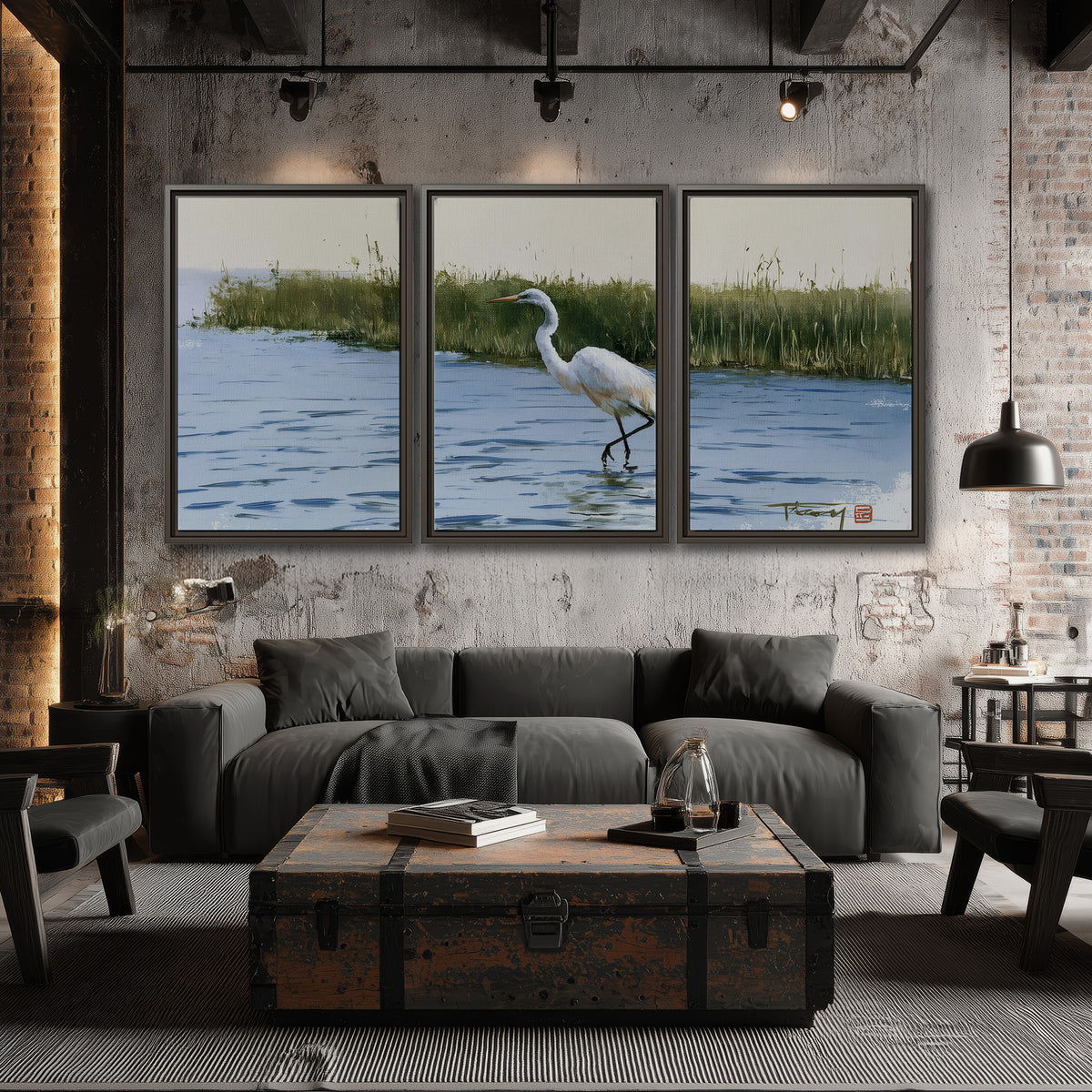 A white heron wading through bright blue water beside green reeds 3 piece framed canvas wall art displayed in a industrial room