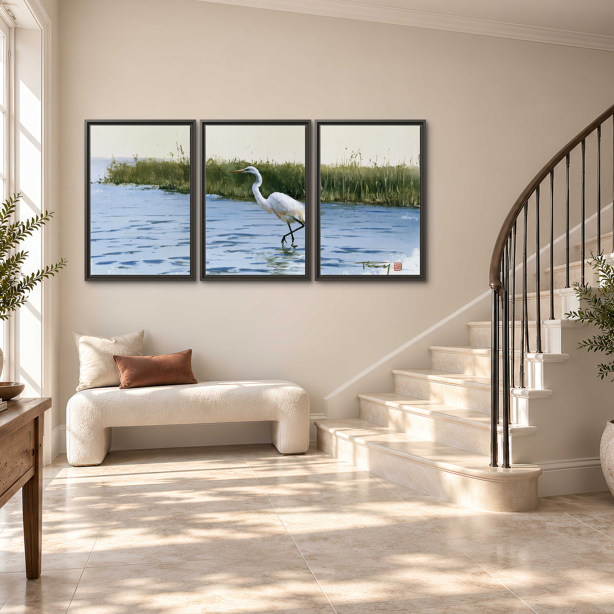 A white heron wading through bright blue water beside green reeds 3 piece framed canvas wall art styled in an interior